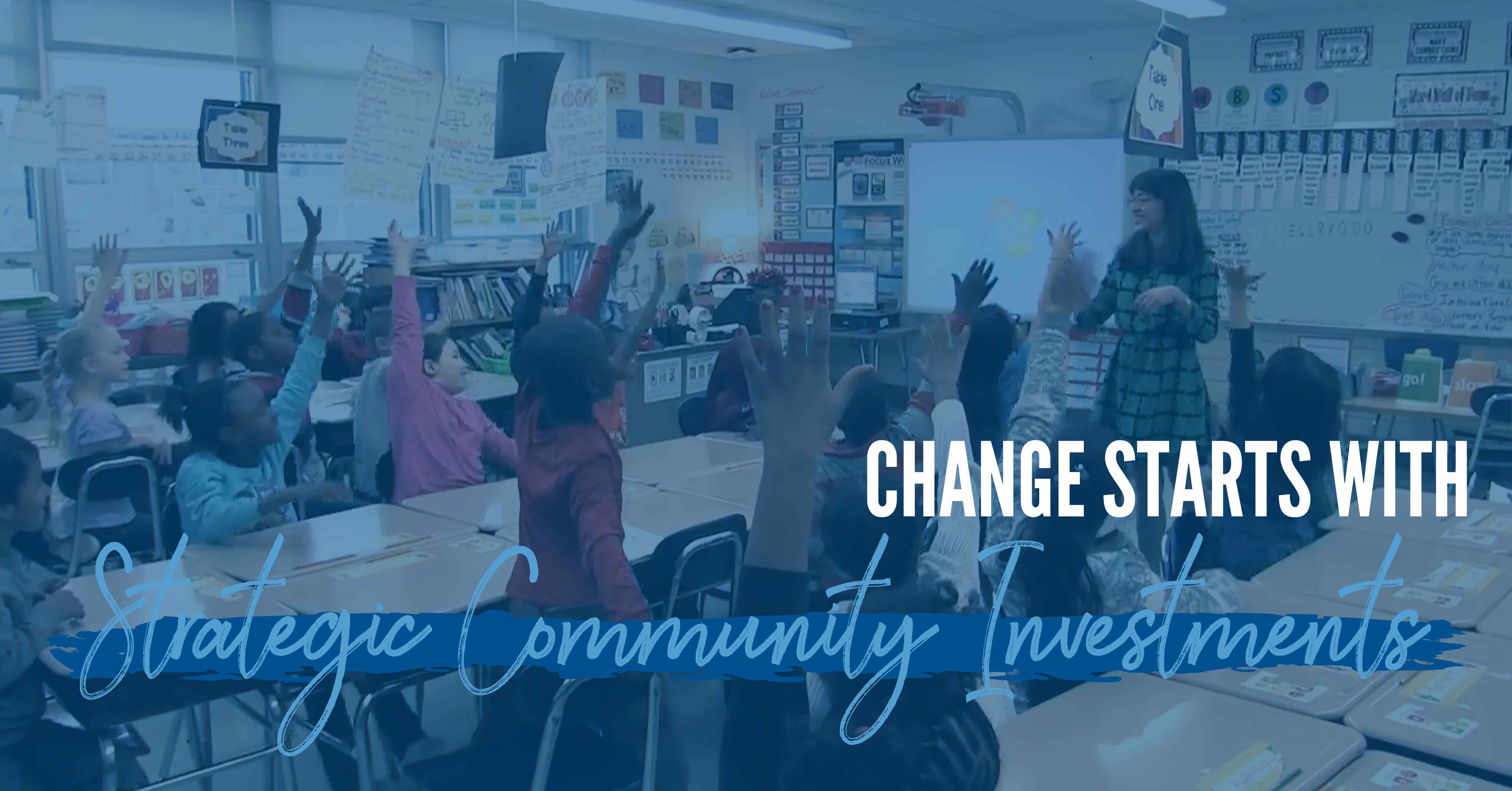 A diverse classroom of young children with their hands raised, blue overlay and the words "change starts with strategic community investments"